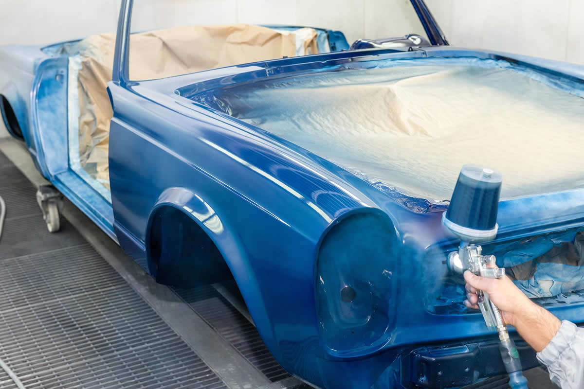 industrial spray painting of a car requiring filtration to protect equipment